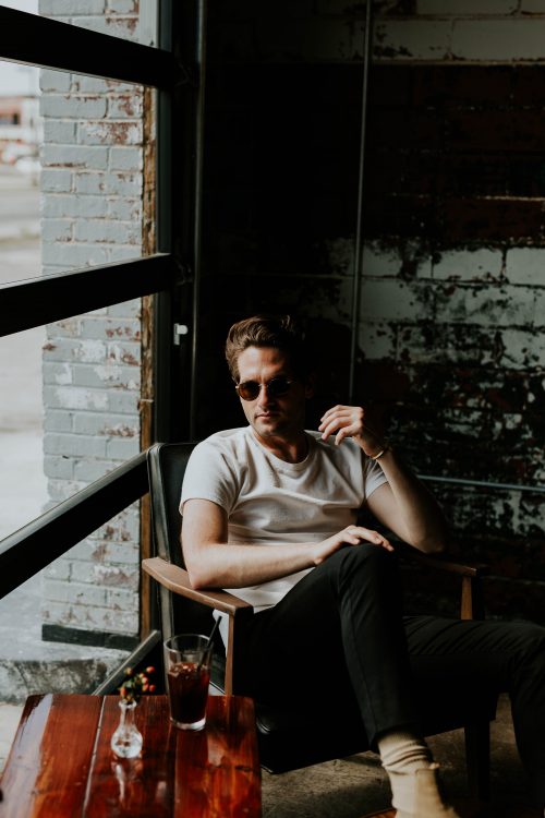 Homme en t-shirt blanc, jean noir et lunettes de soleil