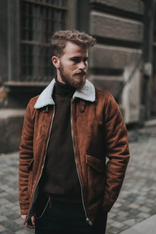 Homme avec un blazer en cuir marron et un sweat noir 